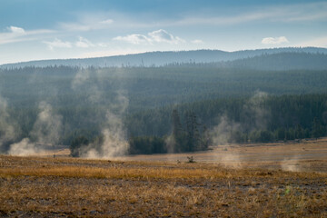 Steam rises from hot springs in Yellowstone National Park in the early morning hours in autumn