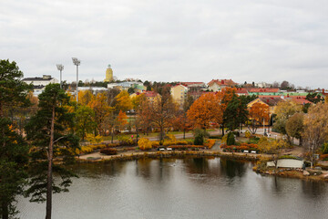 Fototapeta premium Beautiful urban autumn landscape with a calm lake. Panoramic view of the town of Kotka, Finland.