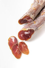 Dried sausage sliced into slices on a white plate. Elite meat product