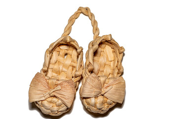 bast shoe on a white background. Two wicker bast shoes tied together.