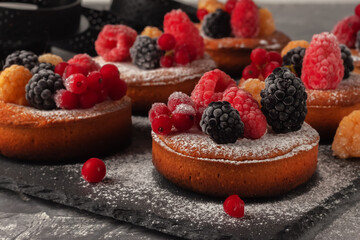 Fresh small homemade fruit tarts with raspberries, currants and blackberries