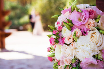 Real wedding bouquet for newlyweds which is blurred on the background
