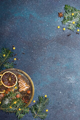 Beautiful Christmas background with decorations. Christmas cookies witch chocolate, gingerbread cookies, nuts and fir twigs on dark background. Copy space for your text