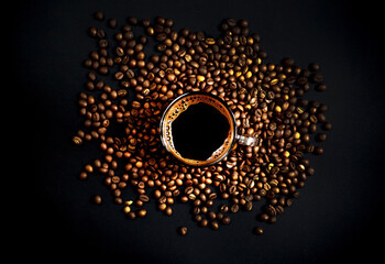  top view of coffee cup with coffee beans on black background