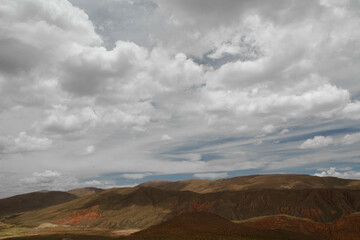 Desert landscape. Aerial view of the brown arid mountains and valley under a beautiful cloudy sky.