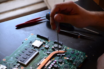 The man hand of the technician assembling inside of tablet by screwdriver in the lab. the concept...