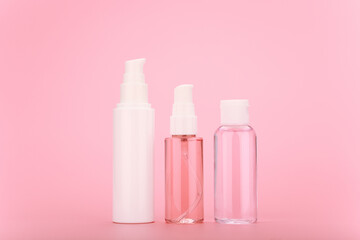 Beauty concept, minimalistic still life with face cream, skin foam for cleaning and lotion on a bright pink background