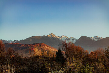 Autumn landscape with snow capped mountain peaks.