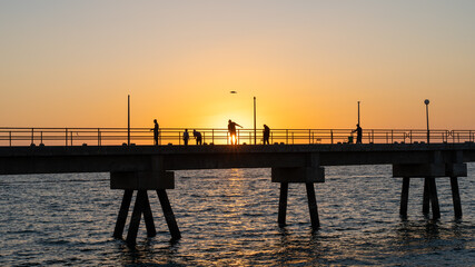 Fototapeta premium Pier with fishermen at sunset on Masirah Island in Oman