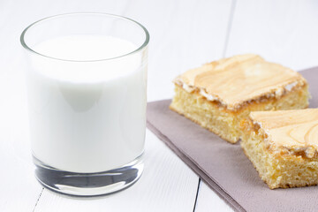 A glass of milk and cake on a white wooden background. Breakfast in a morning. Healthy food