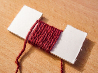 Fototapeta na wymiar strand of wool wrapped around a piece of cardboard