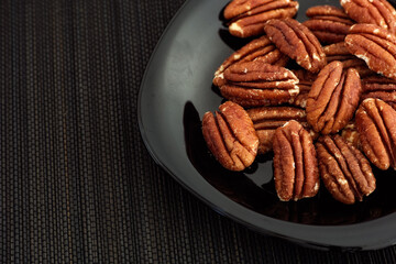 Pecan nuts in a plate. Low key.