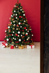 Fototapeta na wymiar New Year's Interior with Christmas Tree with gifts decor garland December 2021