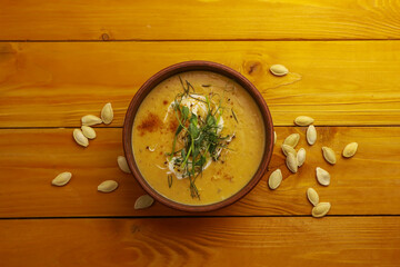 Tasty pumpkin soup on wooden background