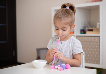 Child doing exercise fine oral motor practice, home education, easy diy activities for preschooler.