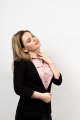 Photo of a woman on a light background. The woman touches her neck with her hand. The body is slightly turned to the right. The eyes are closed. High quality photo