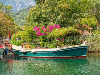 wooden boat on the river with flowers in summer day