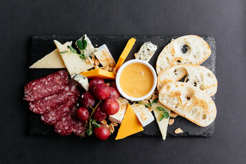 cheese and meat cuts on a black background
