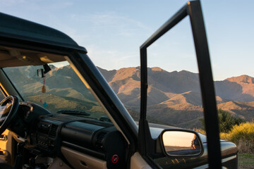 Black 4x4 car on the peak of the hill with mountains on background. concept, car trip through nature. Marbella, Malaga, Andalusia, Spain. © Avril