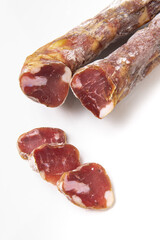 Dried sausage sliced into slices on a white plate. Elite meat product