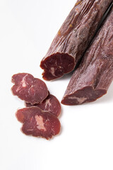 Dried sausage sliced into slices on a white plate. Elite meat product