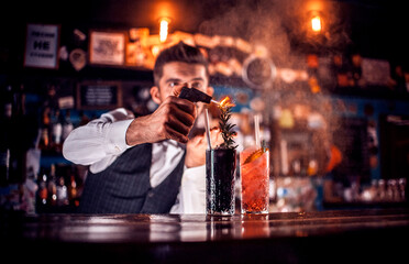 Professional Female bartender intensely finishes his creation at the nightclub