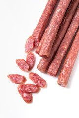 Dried sausage sliced into slices on a white plate. Elite meat product