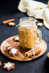 Pumpkin spiced latte or coffee in a cup on turquoise vintage background. Autumn, fall, or winter hot drink. Cozy breakfast or snack.