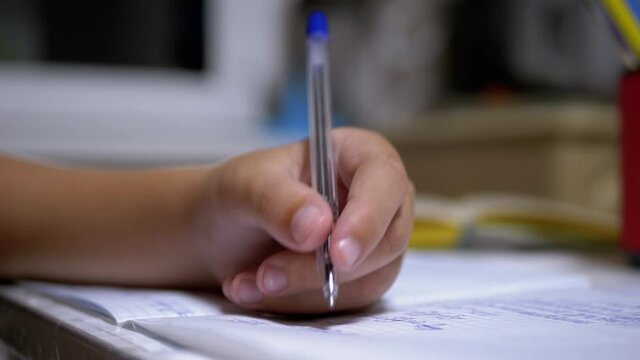 Schoolboy Writes with Left Hand in Notebook, Using Handle. Online Home Training