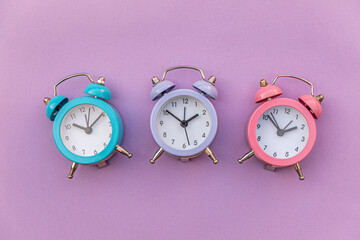 Simply minimal design three ringing twin bell classic alarm clock Isolated on purple violet...