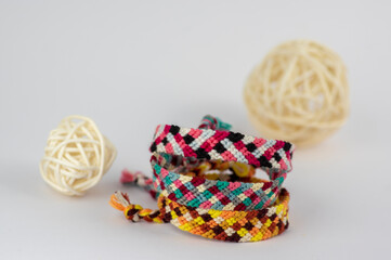 Group of handmade homemade colorful natural woven bracelets of friendship isolated on white background with pedig balls