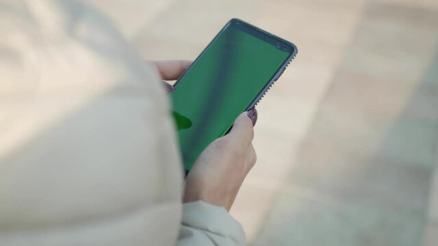 person using smartphone with green screen