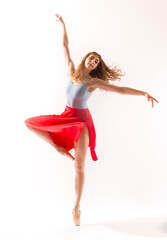 Ballerina in light blue leotard and red skirt, white background.