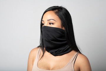 Mixed-Race woman wearing a black gaiter. Studio shot on white.