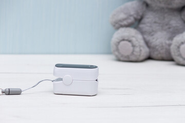Pulse oximeter for measure pulse rate and oxygen level on white wooden table. Healthy concept.