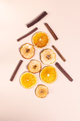 Fototapeta na wymiar Festive Christmas tree made from cinnamon sticks, dried oranges and apples. Natural Christmas decor concept. Top view. Vertical orientation.