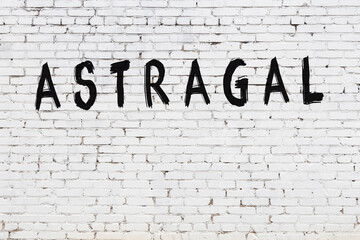 Inscription astragal painted on white brick wall