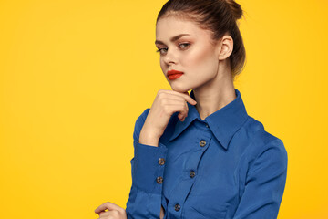 portrait of a strict woman in a blue shirt with red lips on a yellow background emotions fun