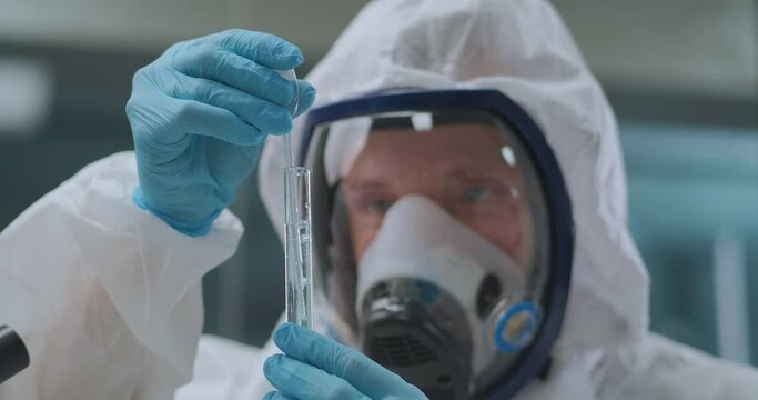 crime expert is researching chemical in test tube in chemistry laboratory, portrait of male scientist