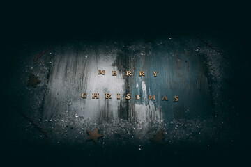 Christmas decoration on rustic wooden background with Merry Christmas text, high angle view and dramatic light