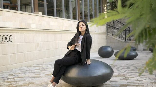 brunette girl in black walk in old town in sunny day portrait video