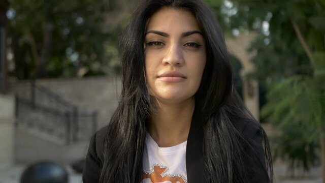 brunette girl in black walk in old town in sunny day portrait video