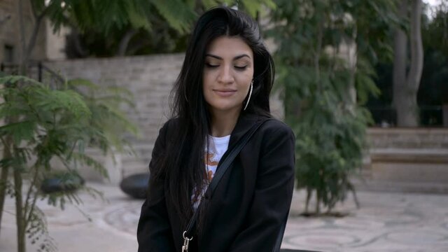 brunette girl in black walk in old town in sunny day portrait video