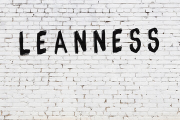 White wall with black paint inscription leanness on it