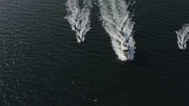 Aerial top down, tracking boats heading back into harbour after a day of hire for group and crew on board 4k