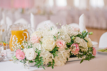 Wedding flower decoration made of white and pink roses on the banquet table