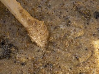 Closeup of a wooden spoon stirring honey