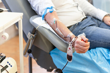 male hand with dropper, bag for collecting blood, bouncy ball in the form of heart in the transfusion unit. donation. soft focus