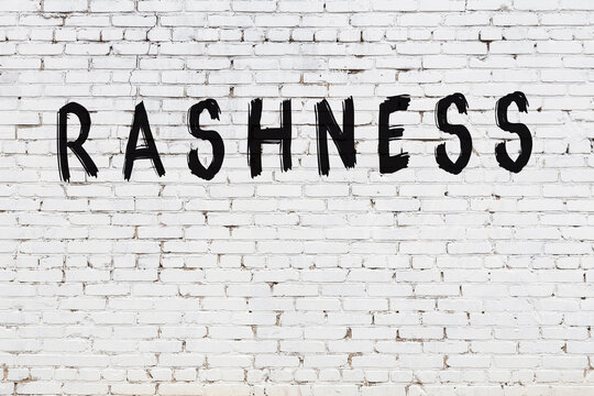 Inscription rashness painted on white brick wall