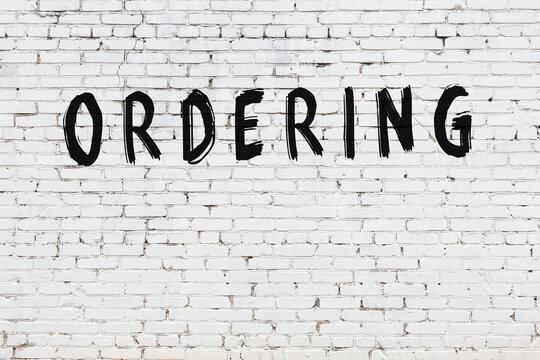 Inscription ordering painted on white brick wall